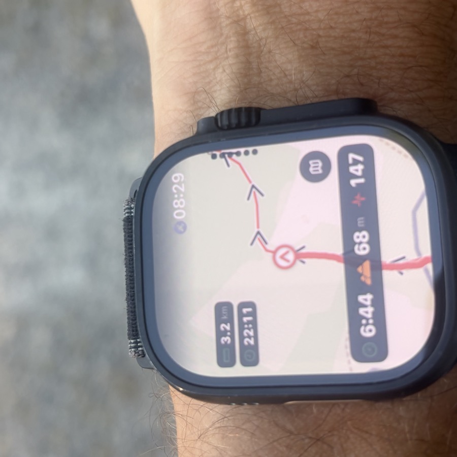An Apple Watch Ultra mid-run showing the Peak Days route map with direction arrows, distance, pace, climb and heart rate